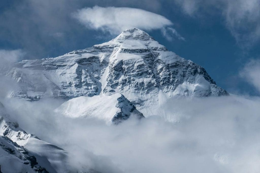Snow-covered Mount Everest under a bright blue sky in Tibet, China