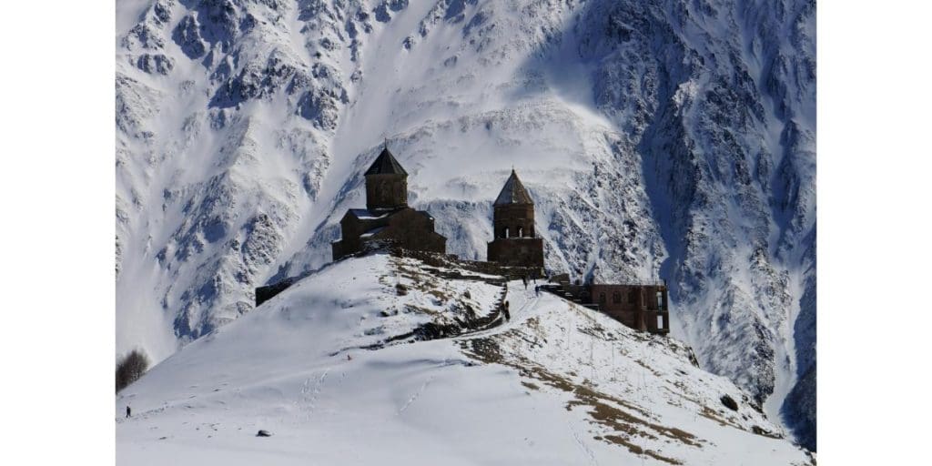 Church perched on a hill with Mount Kazbek, one of the highest mountains in Europe, in the background