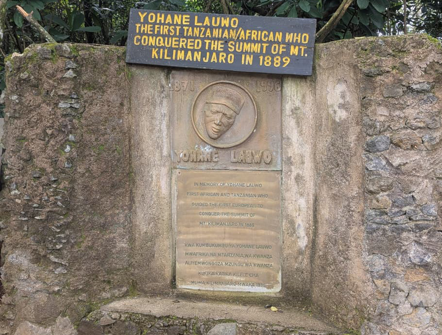 Commemorative plaque at Marangu Gate honoring Yohane Lauwo, the first Tanzanian and African who conquered the summit of Mount Kilimanjaro in 1889.