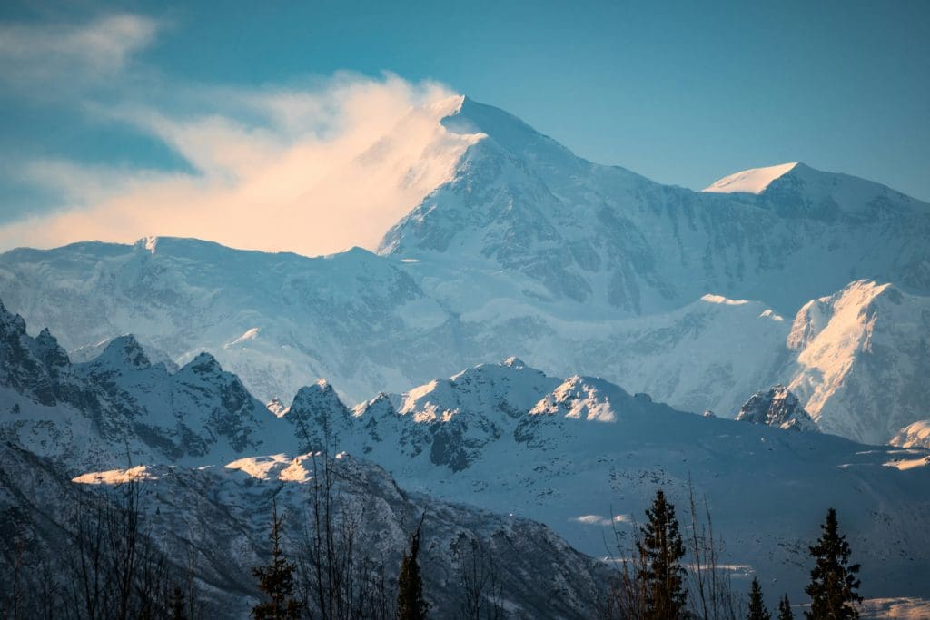 Denali mountain peak surrounded by clouds in Den