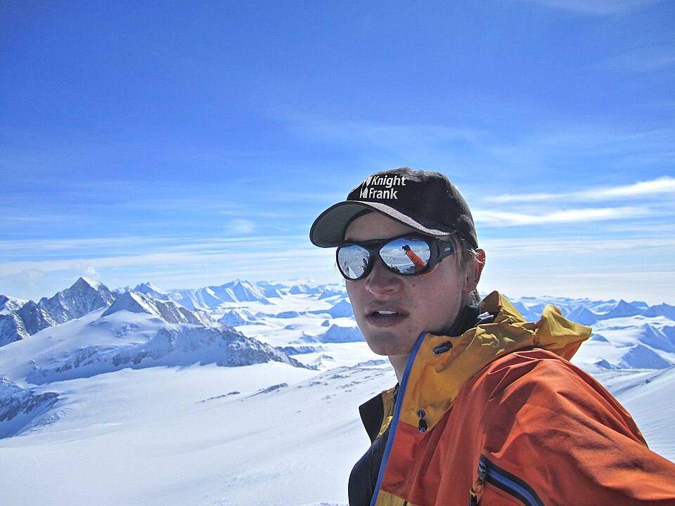 A climber celebrating atop the highest peak in Antarctica.
