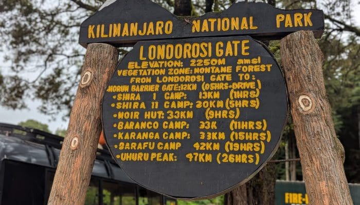 Londorosi Gate sign at Kilimanjaro National Park showing elevation and distances to camps and Uhuru Peak